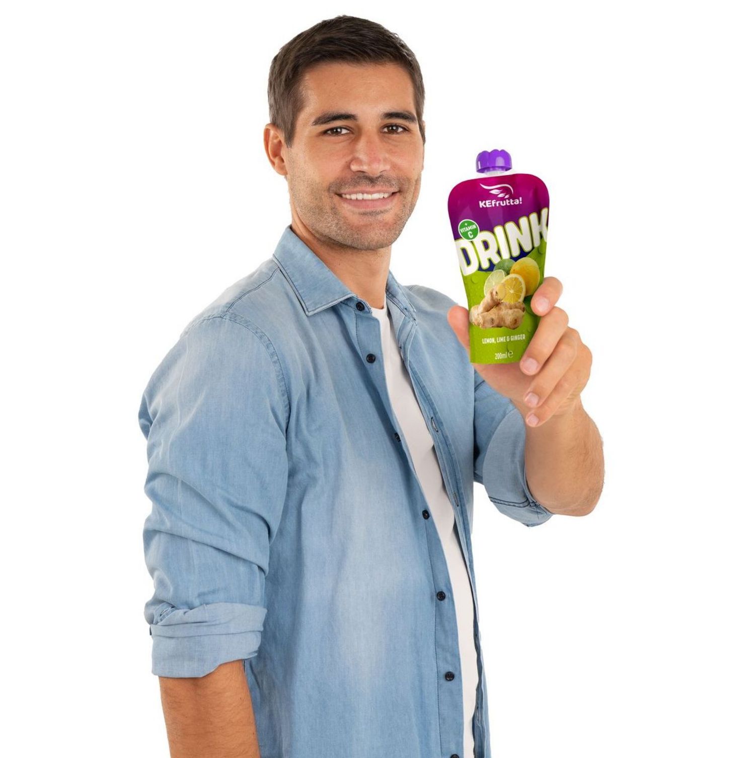 Ein lächelnder Mann in blauem Denim-Hemd hält eine Portionspackung KEfrutta! Drink mit Zitrone und Ingwer in die Kamera.